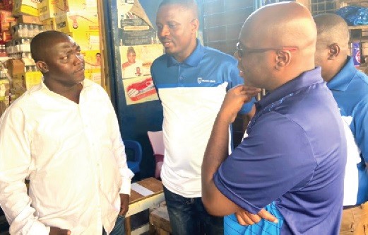 Kwamina Asomaning (2nd from left), Chief Executive of Stanbic Bank, and other staff of the bank in a conversation with Kweku Amoah (left)